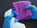 Male hand in blue glove holding microfiber cleaning cloth and spray bottle with sterilizing Royalty Free Stock Photo