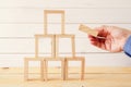 male hand building tower from domino wooden blocks