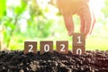 Male hand burying year 2020 to change to 2021 in wooden blocks cubes. New year, hello and goodbye concept. Royalty Free Stock Photo