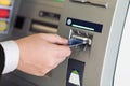 Male hand businessman inserts credit card into the ATM