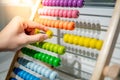 Male hand calculating beads on rainbow abacus Royalty Free Stock Photo