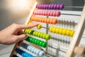 Male hand calculating beads on rainbow abacus Royalty Free Stock Photo