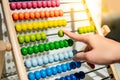 Male hand calculating beads on rainbow abacus Royalty Free Stock Photo