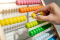 Male hand calculating beads on rainbow abacus Royalty Free Stock Photo