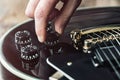 Male hand changing electric guitar settings. Tuning a timbre regulator Royalty Free Stock Photo