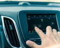 Male hand changing the radio station on car LCD infotainment screen Royalty Free Stock Photo