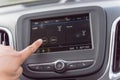 Male hand changing the radio station on car LCD infotainment screen Royalty Free Stock Photo