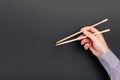 Male hand with chopsticks on black background. Traditional asian food with emty space for your design Royalty Free Stock Photo
