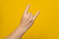 Male hand close-up on a yellow background shows hand gesture. Rock'n'roll. Isolate Royalty Free Stock Photo