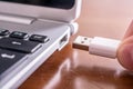 Male Hand Connecting A White USB Cable To The USB Port Of A Small Notebook Royalty Free Stock Photo