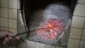 Male hand corrected poker coals in the furnace.