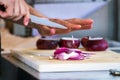 Male hand cutting - chopping red onions, sun light. Royalty Free Stock Photo