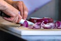 Male hand cutting - chopping red onions, sun light. Royalty Free Stock Photo