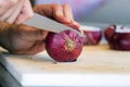 Male hand cutting - chopping red onions, sun light. Royalty Free Stock Photo