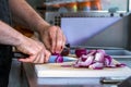 Male hand cutting - chopping red onions, sun light. Royalty Free Stock Photo