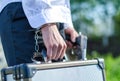 Male hand enchained to suitcase