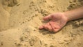 Male hand falling lifeless on sand, death of thirst in sahara, lack of water