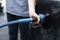 Male hand fills car with gasoline at the gas station holding a gaspump nozzle