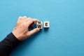 Male hand flipping wooden cube to change the word me to we. Teamwork, partnership, cooperation, team collaboration Royalty Free Stock Photo