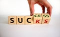 Male hand flips wooden cubes and changes the word `sucks` to `success` or vice versa. Beautiful white background, copy space. Royalty Free Stock Photo