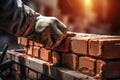 male hand in glove of bricklayer installing bricks on construction site