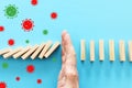 A male hand in glove stopping the domino effect. covid 19 or coronavirus blocking concept Royalty Free Stock Photo