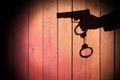 Male Hand with Gun and Handcuffs on Natural Wood Background, XXX Royalty Free Stock Photo
