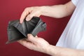 Male hand hold empty wallet on red background, counting a bundle of money, concept of cash, payments Royalty Free Stock Photo