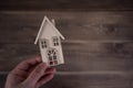 Male hand holdin a wooden house on a wooden background. Buying a house with a young family. Affordable housing. banner Royalty Free Stock Photo