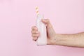 Male hand holding a bottle of milkshake on a pink background Royalty Free Stock Photo