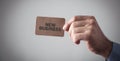 Male hand holding a brown business card. New Business