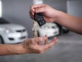 Male hand holding a car key and handing it over to another person Royalty Free Stock Photo