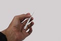 Male hand holding a cigarette on a white background isolation, copy space. Royalty Free Stock Photo