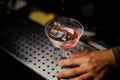 Male hand holding a cocktail glass with sweet alcoholic drink Royalty Free Stock Photo