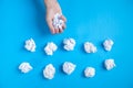 Male hand holding crumpled paper on blue background Royalty Free Stock Photo