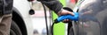 Male hand holding electrical socket while charging electrocar Royalty Free Stock Photo