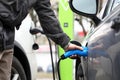 Male hand holding electrical socket while charging electrocar Royalty Free Stock Photo