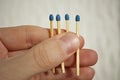 Male hand holding four safety match sticks hidden in the palm with one match stick shorter than the others