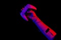 Male hand holding a gamepad in neon light on a black background, top view. Royalty Free Stock Photo