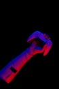 Male hand holding a gamepad in neon light on a black background, top view. Royalty Free Stock Photo