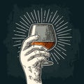 Male hand holding glass brandy with ray. Vintage vector engraving Royalty Free Stock Photo