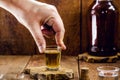 Male hand holding a glass of distilled alcoholic beverage, called