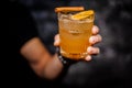 Male hand holding a glass of fresh orange alcoholic drink Royalty Free Stock Photo