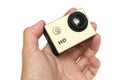 A male hand holding a gold colored small high definition HD action camera