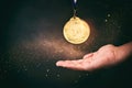 Male hand holding golden medal over dark background and light burst Royalty Free Stock Photo