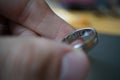 Male hand holding a golden wedding ring with an engraved year 2016