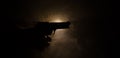 Male hand holding gun on black background with smoke ( yellow orange red white ) colored back lights, Mafia killer concept Royalty Free Stock Photo