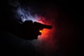 Male hand holding gun on black background with smoke ( yellow orange red white ) colored back lights, Mafia killer concept Royalty Free Stock Photo