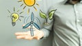 Male hand holding icons of sun bulb leaf-concept of the eco system, ecology Royalty Free Stock Photo