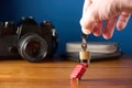 Male hand holding keys and padlock locked on miniature toy suitcase. Concept of travel insurance, safe travel. Blue background wit